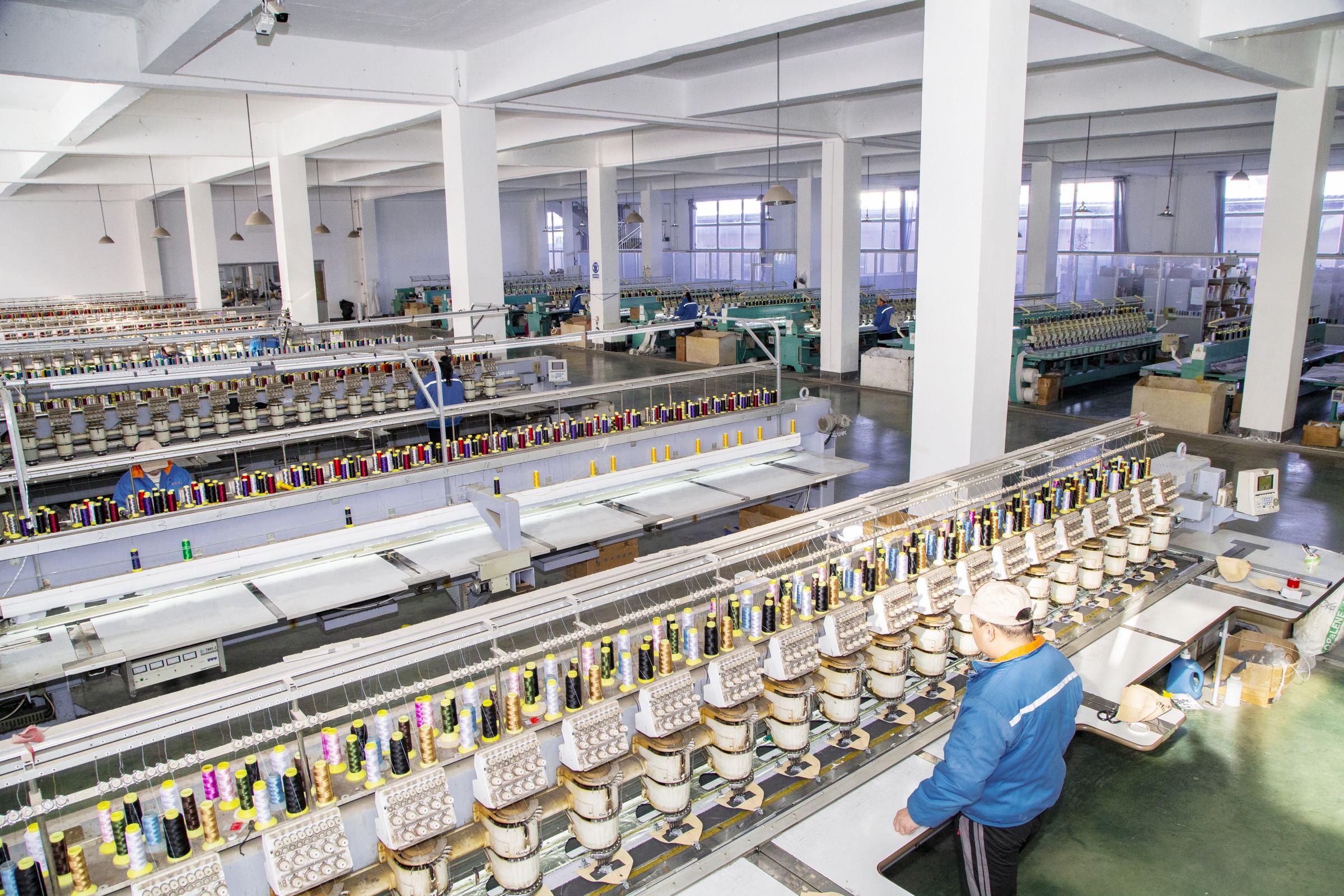BAEZ structured cap factory workshop floor with embroidery machine rows